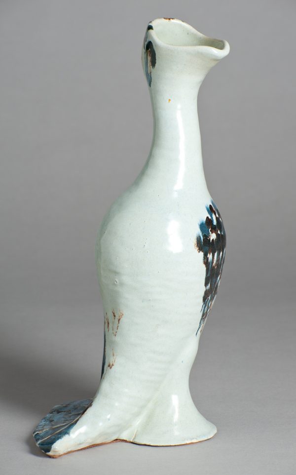 Bottle in the rough shape of a bird, white with blue