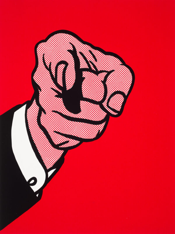 A hand fills the composition with the index finger pointed at the viewer. The clothes shown is a black sleeve, over white cuff. All are shown on a red background.