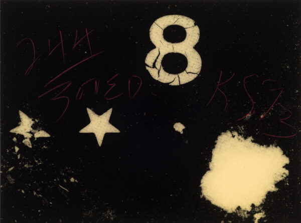 In black over yellow, he number 8 is stenciled at top, two stars at left and another shape at bottom right.