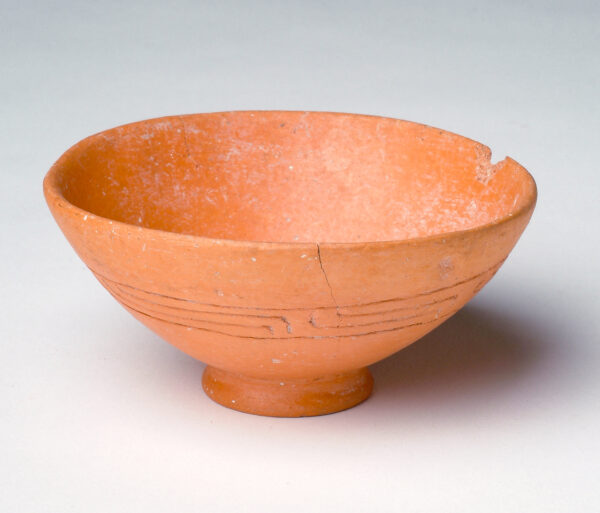 Footed bowl in red slip with geometric band around bowl.