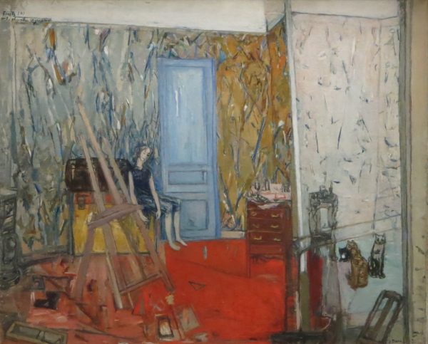 An artist's studio with figure near doors. the walls are covered with random paint strokes. The floor is a bright red color. There is an empty easel to the left of the small figure.