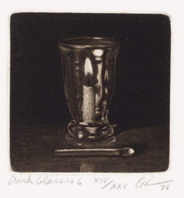 A drinking glass with a candle inside and a match in front.