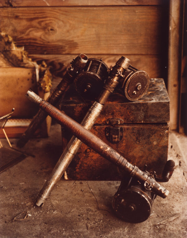 A photograph of a box and fishing rod parts.