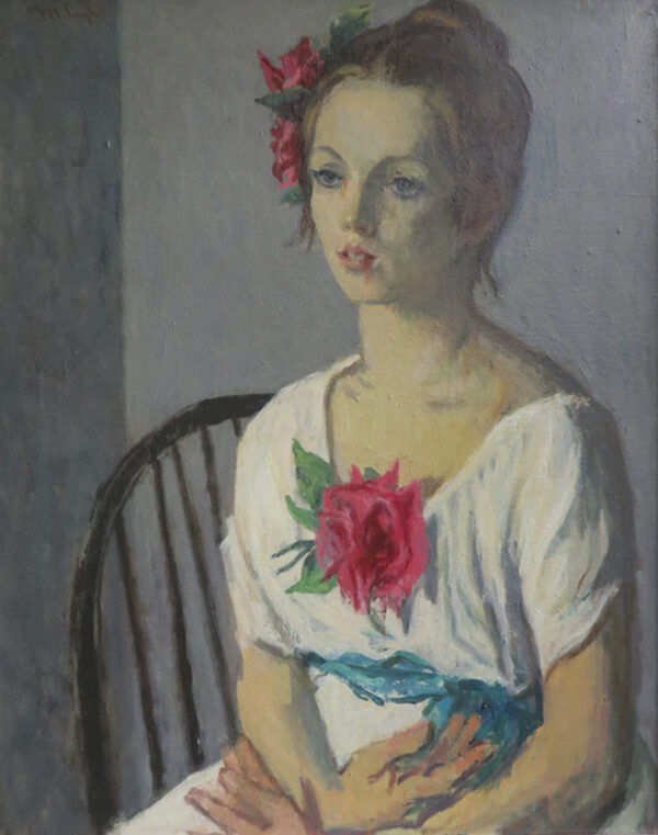 A girl seated with hands in her lap wears roses on her dress.
