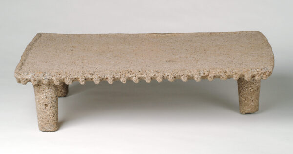 Tripod metate with flat top, short legs.