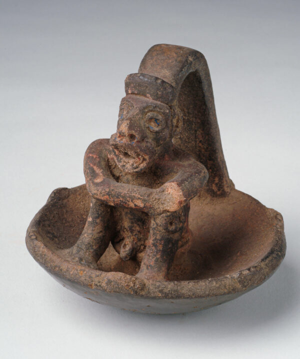 A shallow bowl with seated figure as part of the handle.