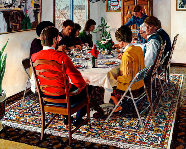 A family gathers for a dinner. There is a colorful rug beneath them.