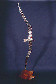 A sculpture of a bird in flight made of stainless steel, bronze, copper, nickel silver and 2-part wood base
