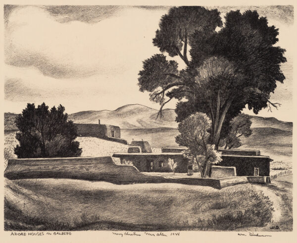 View of adobe buildings, with large tree at upper right; mountains beyond.