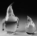 A pair of penguins, one smaller, both looking up.