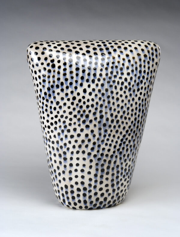 White stoneware vase with black polka dots all over the surface