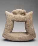 A tool to grind grain with an animal sculpted on the top of the handle.
