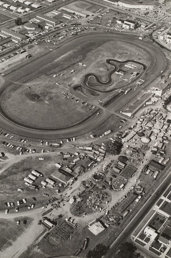 A fairground with the midway at lower right and a race track in the upper half.
