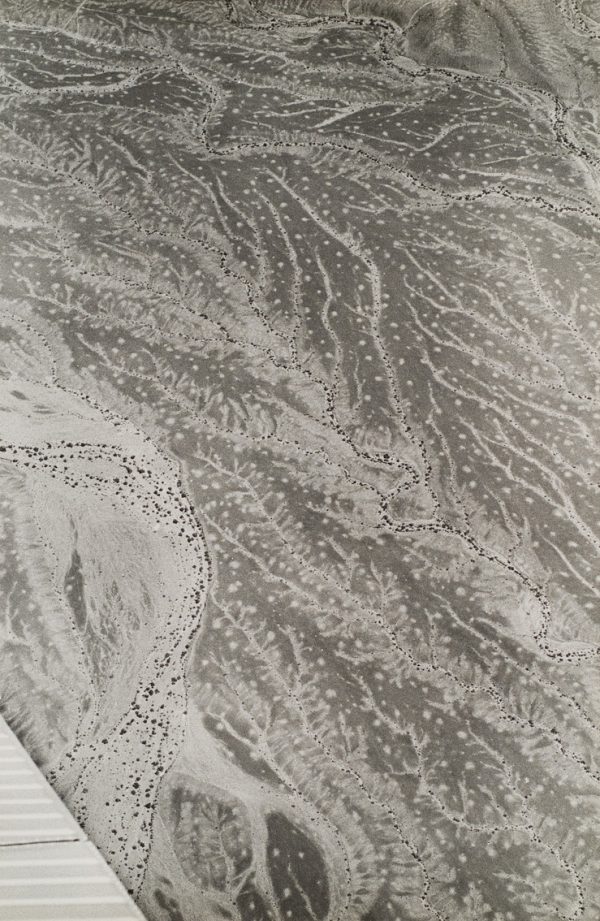 Texture pattern in desert with plane wing at lower left corner.