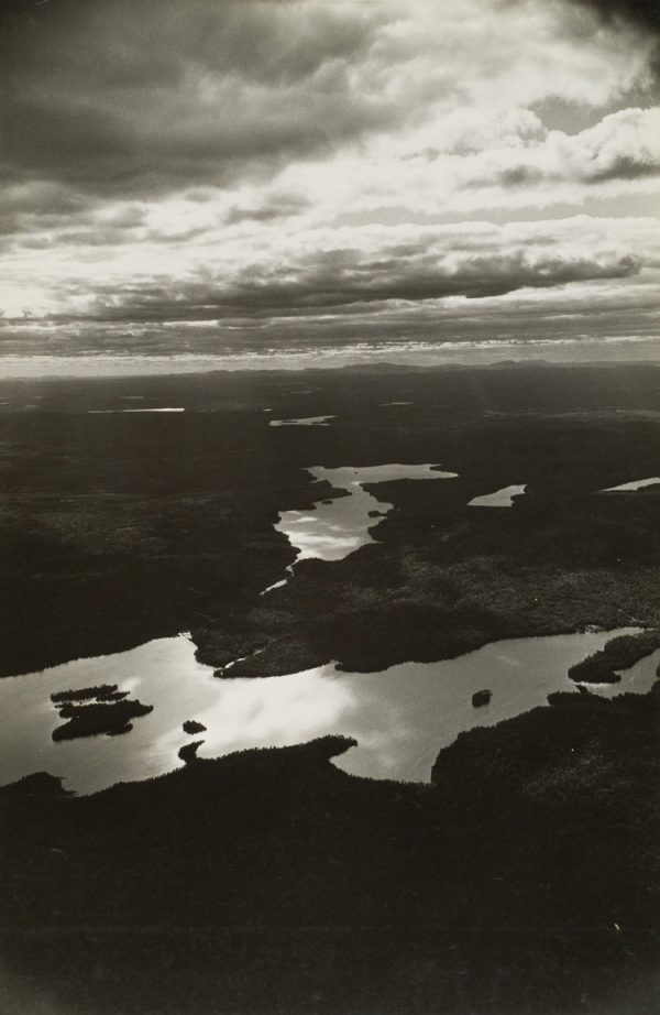 Multiple small lakes in woods with cloudy sky at dawn.