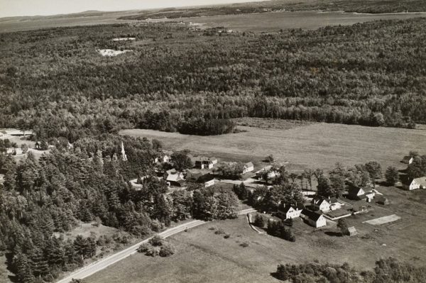 Village with trees and a church steeple to the left of center.