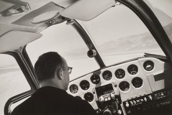 View of cockpit with pilot and Death Valley through windshield