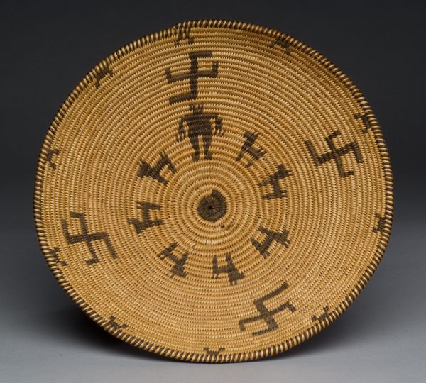 Design is dark brown on tan of circle at center, one human figure, seven double tailed, two legged animals and 4 whirling log designs.