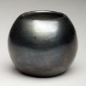 A flat bottomed bowl that is polished undecorated black.