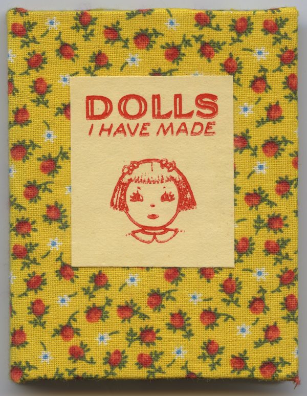 Hard-bound book with red flowers on yellow background cover. Stories about dolls and how to make one out of newspaper.