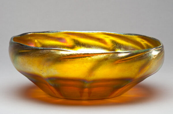 Yellow favrile bowl with flat bottom and swirling sides.