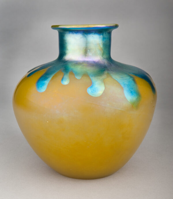 Yellow vase with narrow neck and iridescent glaze around neck and dripped over shoulder of vase.