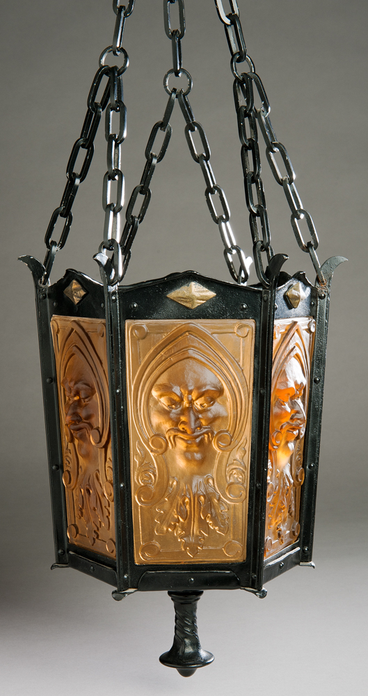 Steuben no. A2112.A hall lamp made of six sides of molded glass in a metal frame with a swirl design lower finial and supported by six chains. Each pane of amber colored glass has a low-relief 