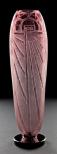 A tall amethyst colored vase in Art Deco style engraved with radiating lines and arches.