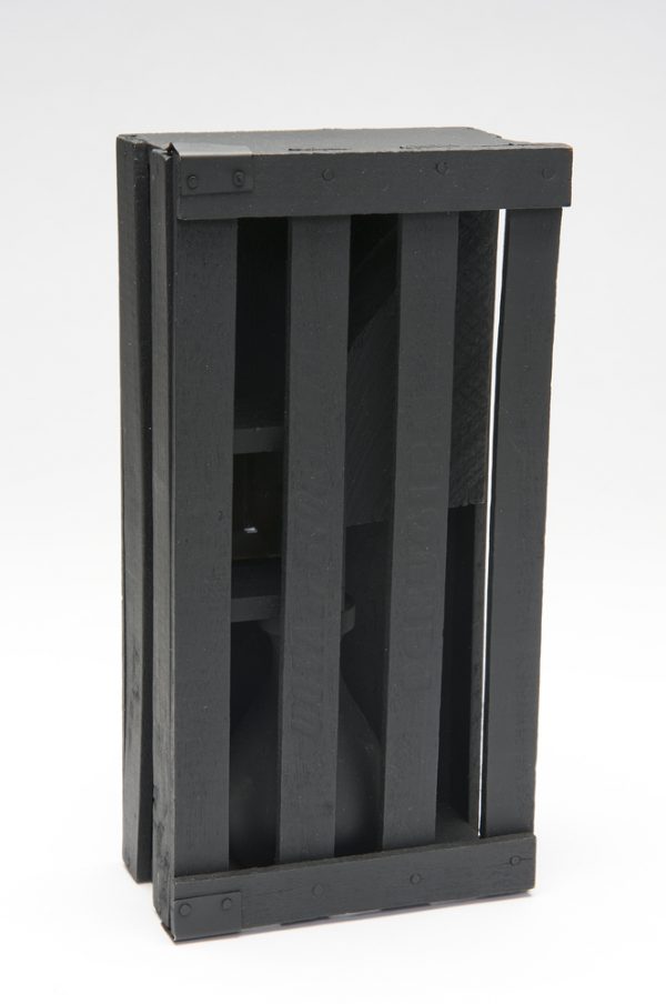 A black wood box with a slat door which opens to display a stack of a vase shape, a box with a mirror and a roughly cut geometric shape.