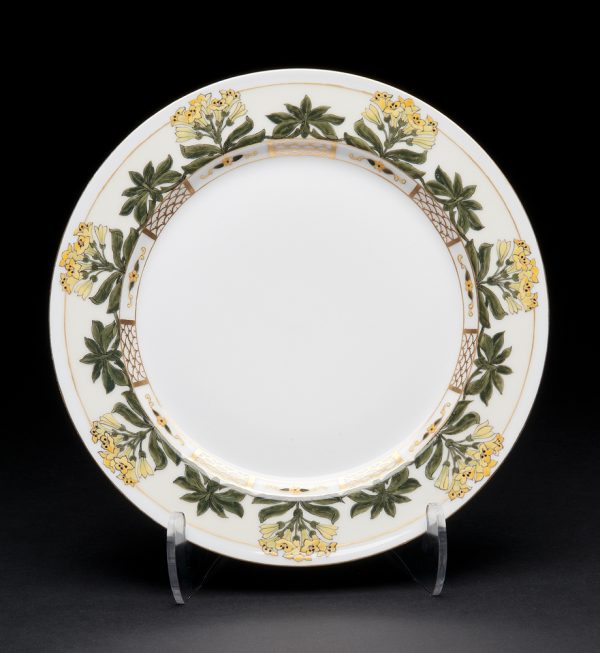 White plate with rim pattern of yellow flowers and green leaves with gold trellis.