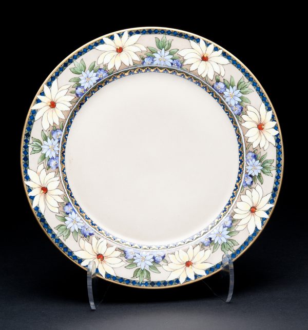 Tan plate with rim pattern of blue diamonds and yellow alternating with blue flowers, gold accents.