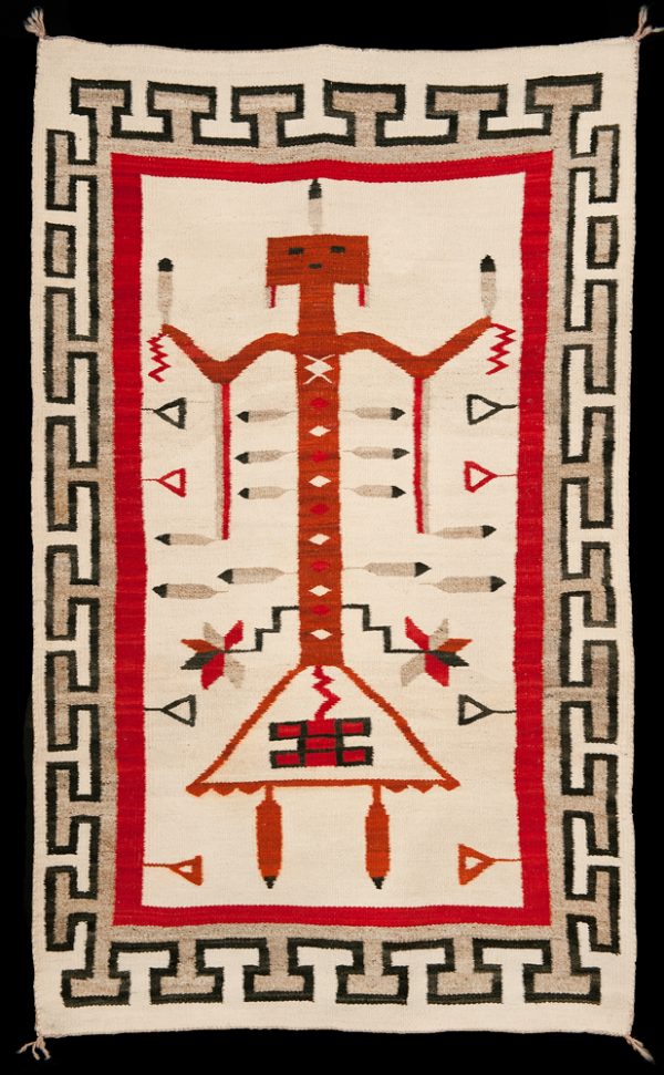 Yei type figure and feathers in central design surrounded by black and tan “T”-shaped border.