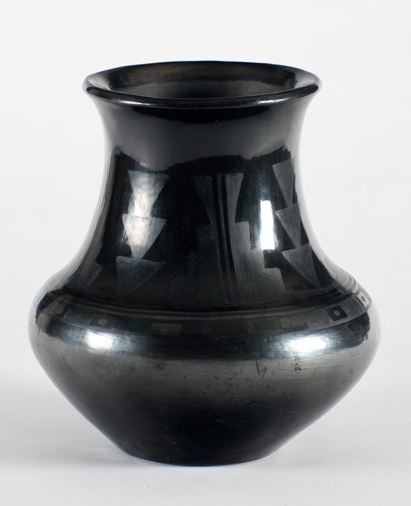 A black-on-black pot decorated with a repeating pattern of three downward pointing triangles within a step design.