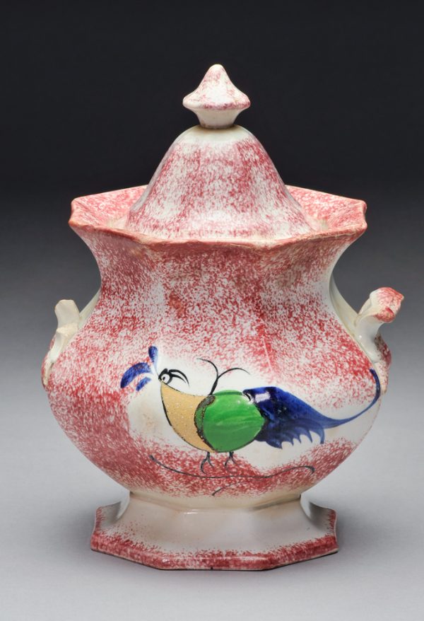 Spatterware covered container in the Rooster Peafowl pattern. The body is red spatter with yellow, green and blue peafowl on one side.