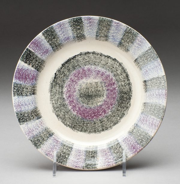 Spatterware plate in black with purple stripes around the rim, with bull's eye center