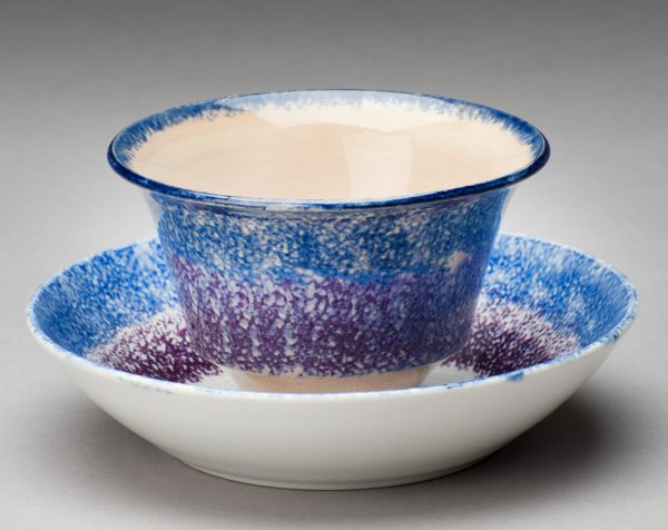 Spatterware saucer in the Rose pattern, blue and purple edge with red rose at center of saucer.