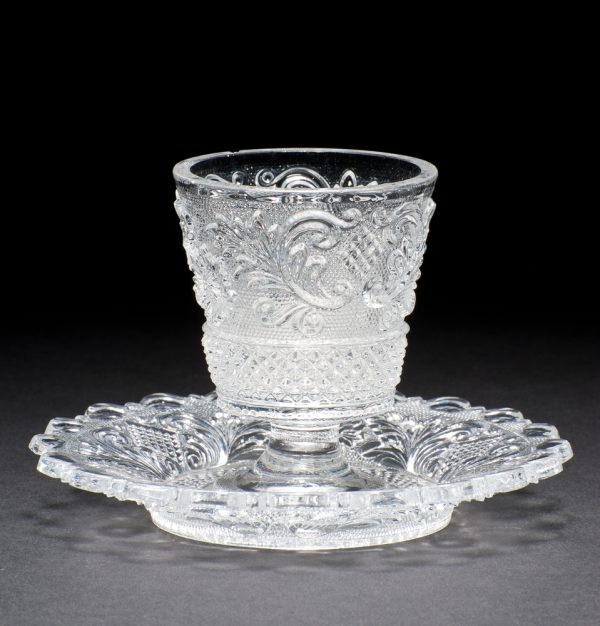 clear, colorless pressed glass with saucer attached