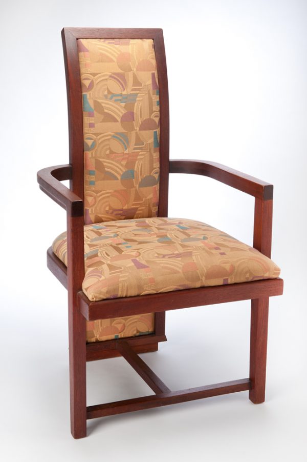 A vertical back with rounded arm rests. The upholstery in a Frank Lloyd Wright pattern covers the seat and the inset of the back.
Manufactured by Heritage Henredon