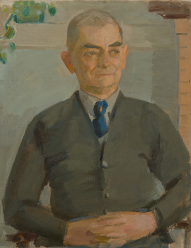 Portrait of a man wearing a blue tie, with hands clasped at waist