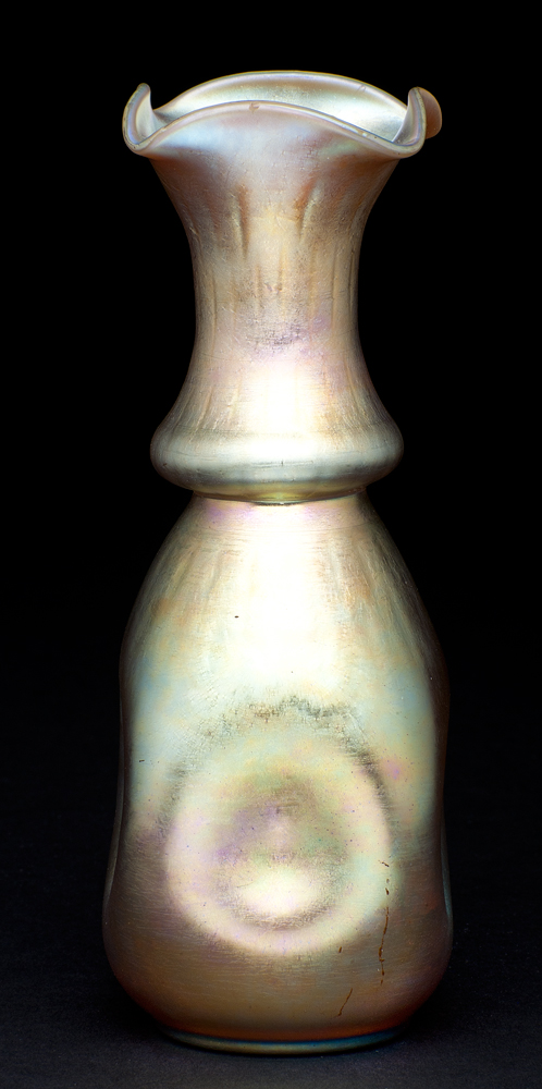 shape #137, A tall vase that starts with a rounded bottom that is indented on four sides. The upper section starts rounded at the center then narrows toward the top with a flared rim that is folded into a square shape.