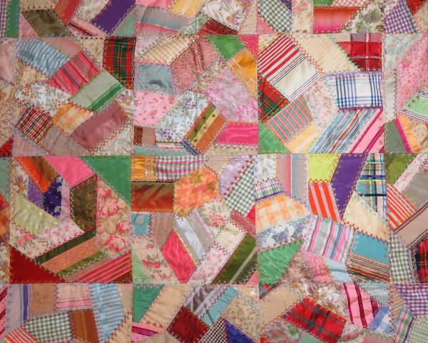 A crazy quilt with top of milliner (hat) ribbons. The quilt was made in approximately 14
