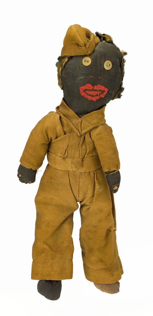 Man in World War I Army uniform, wearing military cap.The doll is dressed in kakhi clothes and hat. He has cloth covered button eyes and felt applique lips. His hair is fur.