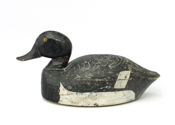 Painted wood decoy with black head, bill and tail, white at belly and wingtips