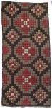 A wool yarn hooked rug in a tight geometric pattern of black, red and white on a brown ground