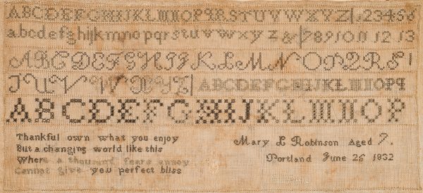 Several alphabets are embroidered in horizontal lines, followed by verse and signature.