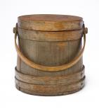 Round wood box with lid and bent wood handle in grey over brown.