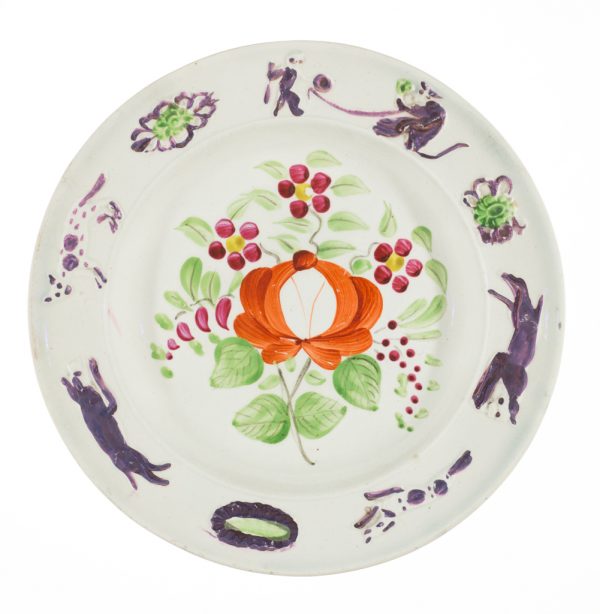 A small plate where monkeys and felines chase each other around the rim of the plate. The center design is in the King’s Rose pattern.