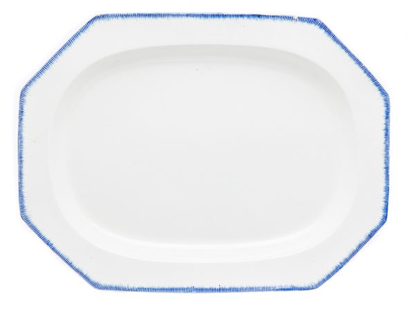 A simple platter with cream ground and blue edges. The edges have a gouged (feathered) pattern.