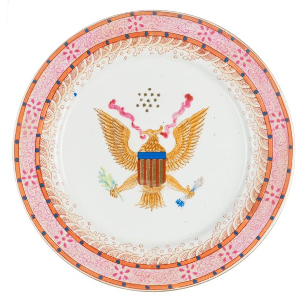 A dinner plate with hand-painted American Eagle and shield pattern at center and oriental wave pattern and flowers around the rim. On the back of the plate there are four rose sprays on the border in red and gold.