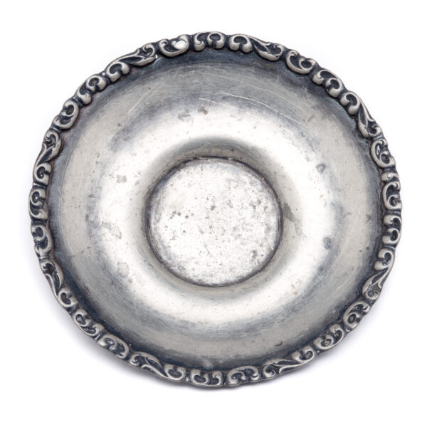 A plain saucer with a scroll design around the rim.